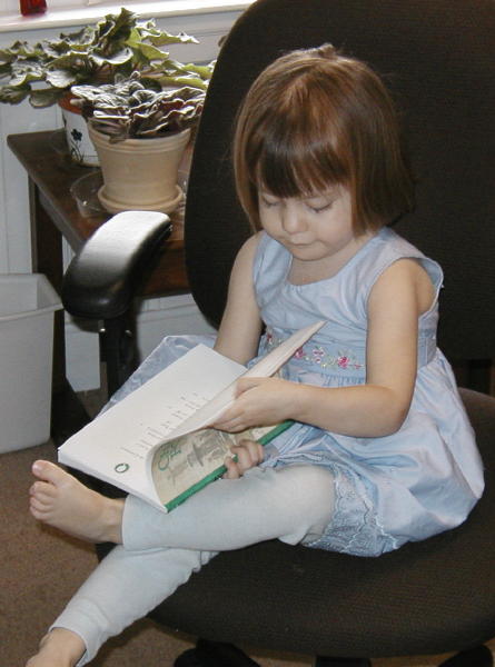 Sophie 'reading' one of sister's books